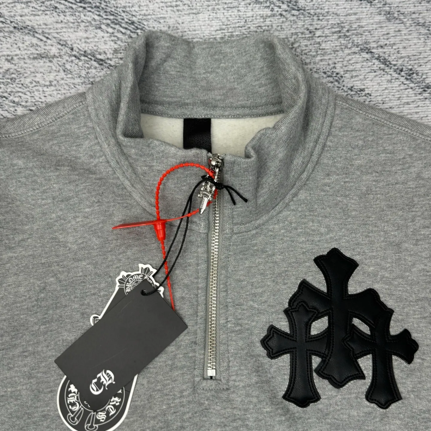 P406 Chrome Heart FW25 leather cross half-zip sweatshirt Size: S/M/L/XL Made of high-weight pure cotton terry fabric Pre-shrunk to ensure wearing stability Three-dimensional leather cross label Half-zip neckline with dagger-shaped zipper pull Combined with curved hem tailoring and kangaroo pocket